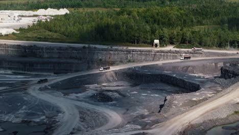 wide angle establishing shot trucks and lorries driving in quarry mine