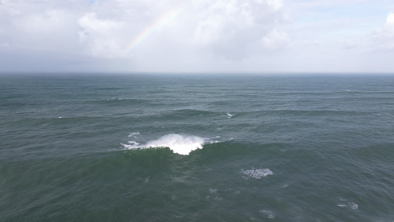 Aerial drone over Nazaré, Portugal as giant Atlantic waves roll to shore. Big wave surfing town seascape