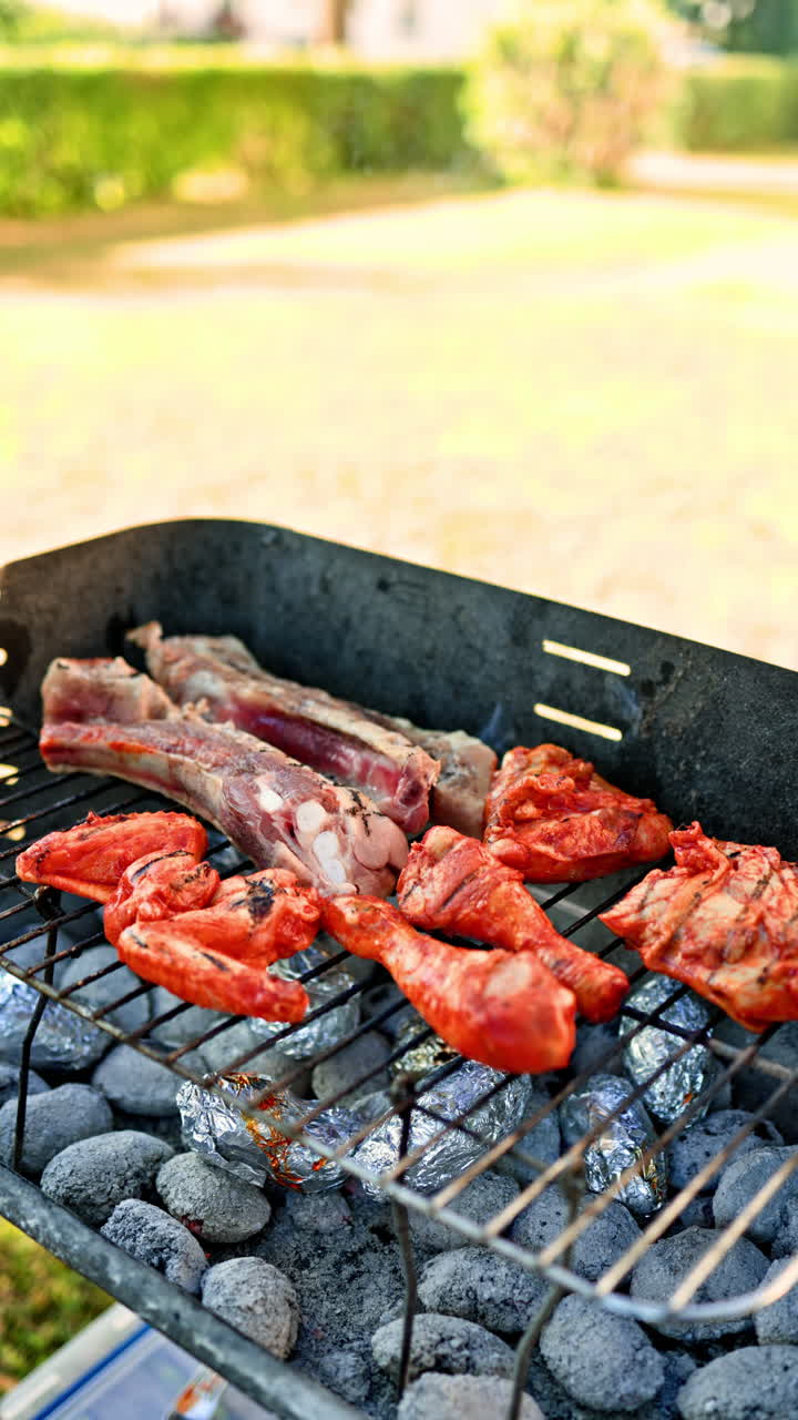 Deliziose cosce di pollo vengono fritte su una griglia da strada. La carne viene fritta su bricchette di combustibile in un barbecue. Griglia aperta in strada con carne sulla graticola