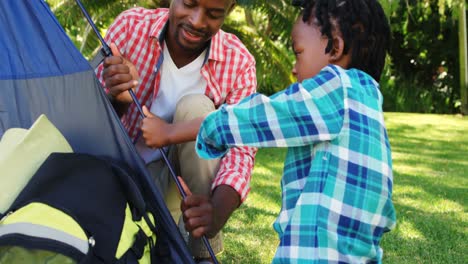 Man-pitching-a-tent-with-his-son