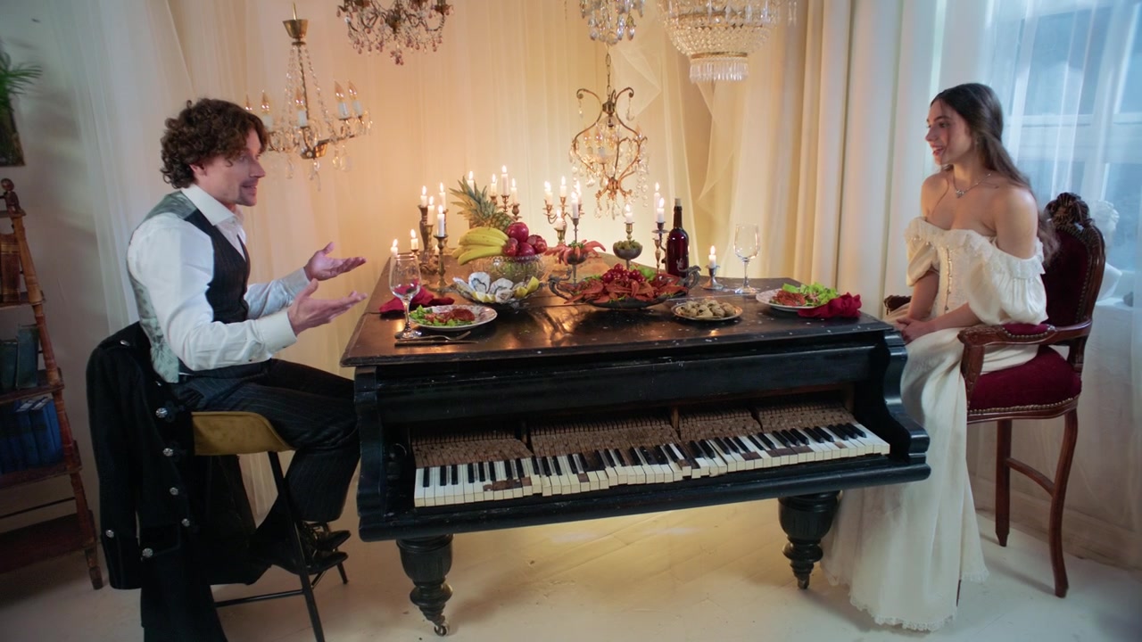 Coppia che si gode una cena romantica a lume di candela a un tavolo pianoforte vintage