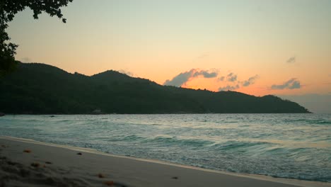 hermosa playa en las seychelles al atardecer con el océano y las montañas en la vista