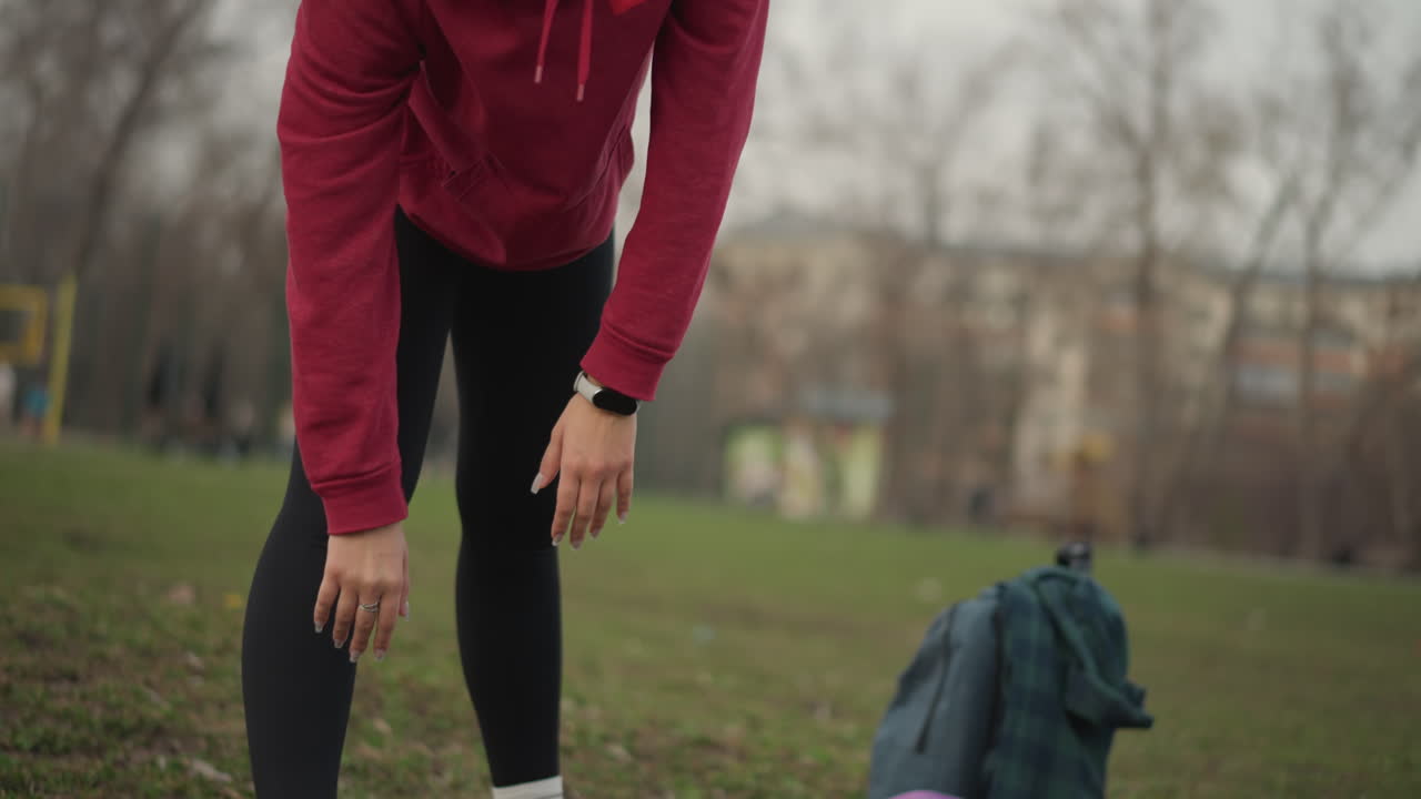 Relaxed Woman Practicing Forward Bend, Quiet Woman In Peaceful Forward Bend Pose With Backpack Nearby, Tranquil Woman Performing Slow Forward Stretch On Yoga Mat With Thoughtful Concentration