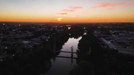 Río-Tamazula-river,-vibrant-dusk-in-Culiacan-city,-Sinaloa,-Mexico---Aerial-view