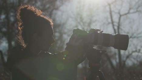 beautiful female wildlife photographer with tripod in nature in colorado