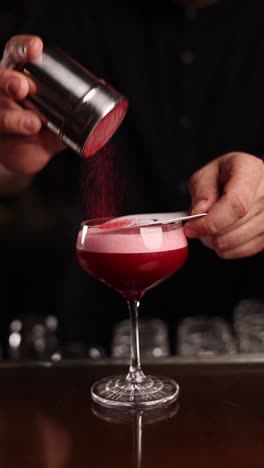 bartender preparing a red cocktail