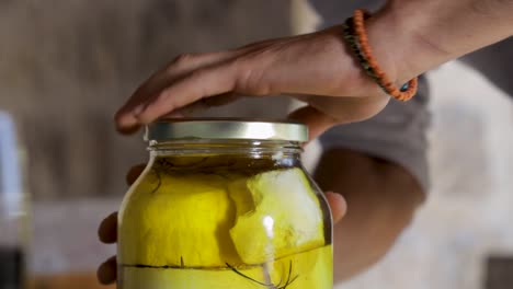 Man-opens-a-jar-with-homemade-cheese