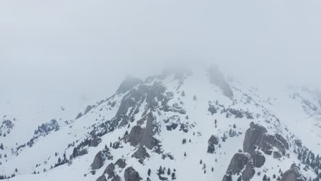 Snow-covered-Ciucas-Mountains-shrouded-in-mist,-serene-winter-landscape