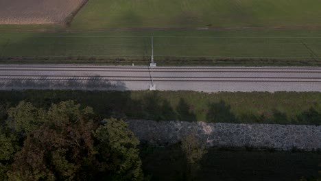 Toma-Aérea-En-Movimiento-Rápido-De-Un-Ferrocarril-Vacío-En-El-Campo-Esloveno-Cerca-De-Las-Tierras-De-Cultivo