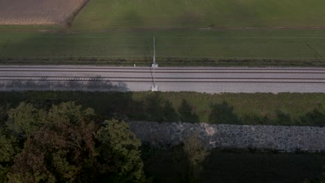toma aérea en movimiento rápido de un ferrocarril vacío en el campo esloveno cerca de las tierras de cultivo