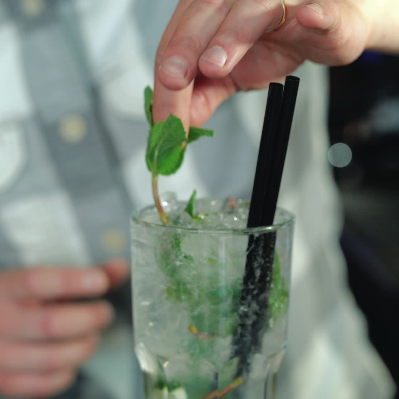 Process of preparing a Mojito cocktail with ice. Barman at work preparing cocktails. Sqare video