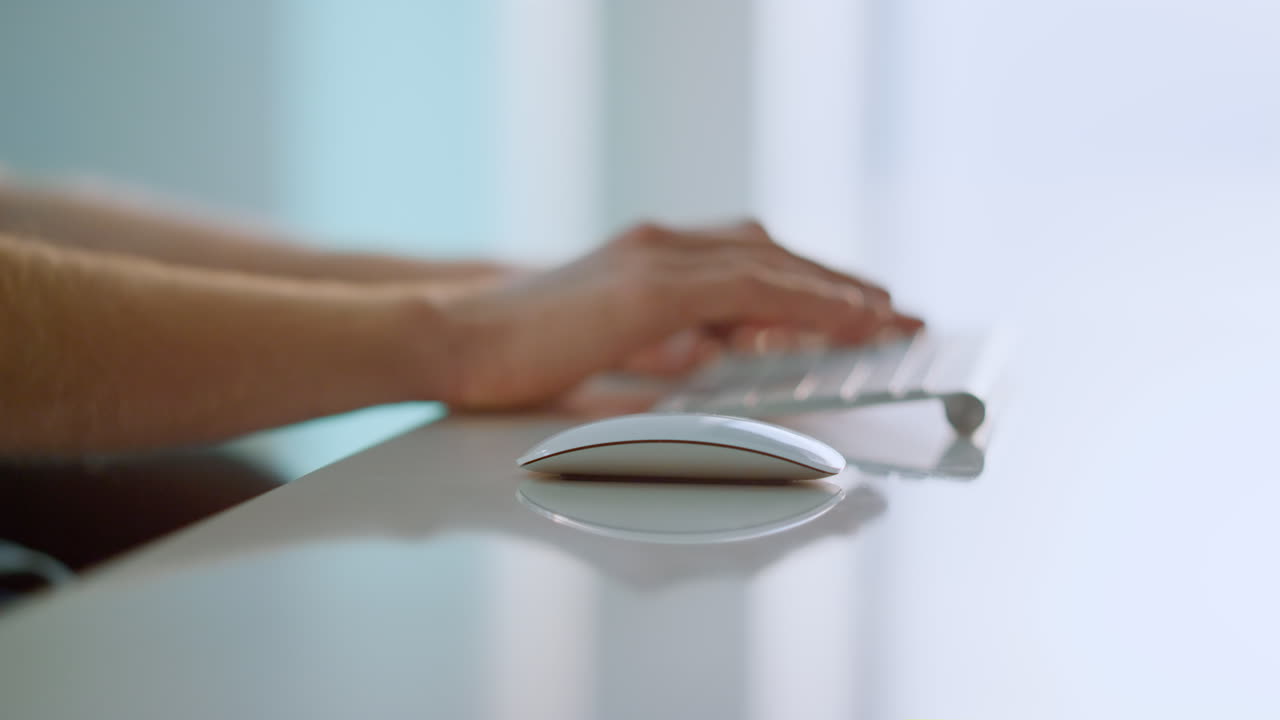 Worker hands holding mouse using wireless device at bright home office closeup.