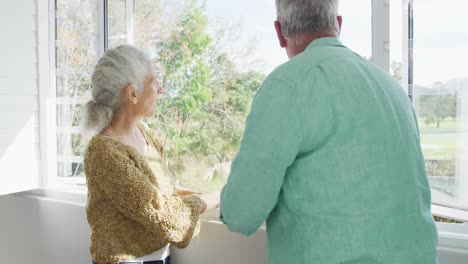 Glückliches-Kaukasisches-älteres-Paar,-Das-Am-Fenster-Steht