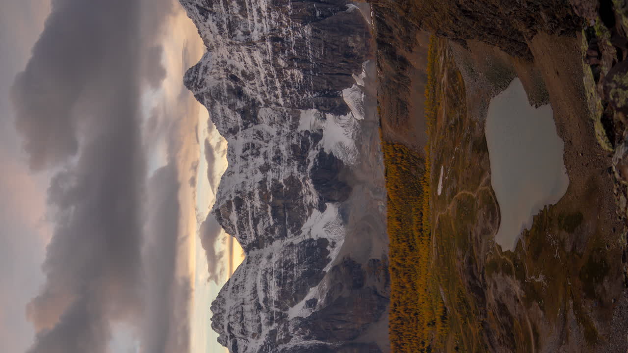 lapso de tiempo vertical de 4k, valle de diez picos, parque nacional de banff canadá, nubes moviéndose sobre cumbres nevadas en el frío día de otoño