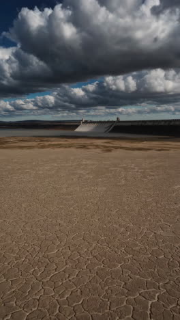 empty reservoir and dry land around a dam