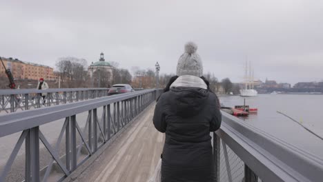 vista tranquila de una mujer viajera paseando por el puente de skeppsholm en estocolmo, suecia