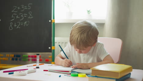 el niño encuentra la solución de un problema difícil de matemáticas en el escritorio.