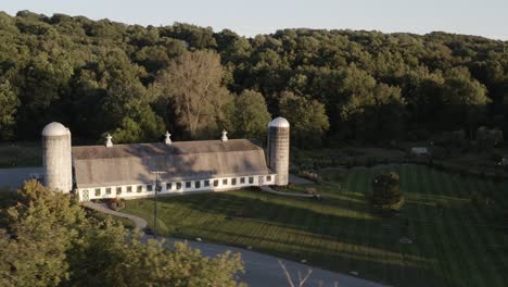 old farmhouse and silos in aerial orbiting view