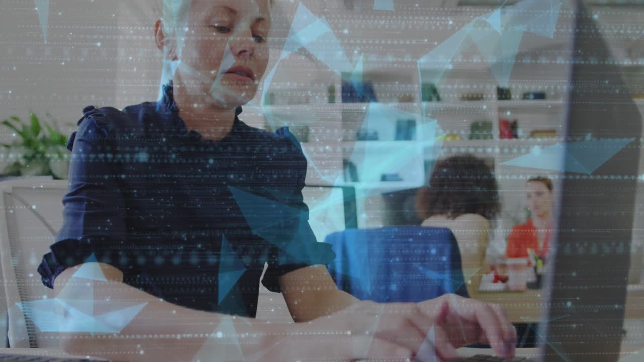 Animation of particles and geometric shapes over caucasian woman working over laptop at office