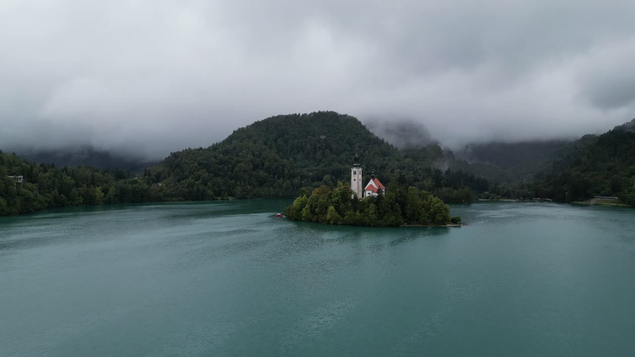 lago bled eslovenia push in drone vista aérea fondo nublado