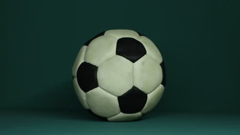 cinematic shot of a single football positioned against a dark, shadowy background