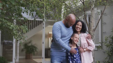 Portrait-of-happy-biracial-parents-with-daughter-in-garden-with-copy-space