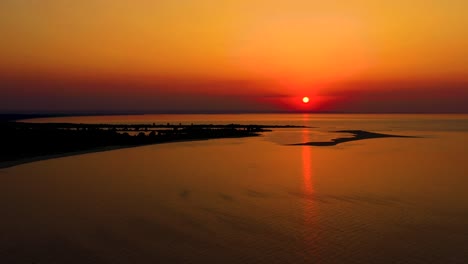 4k uhd aerial drone view beautiful sunset over tropical beach with clouds in the middle of the sea