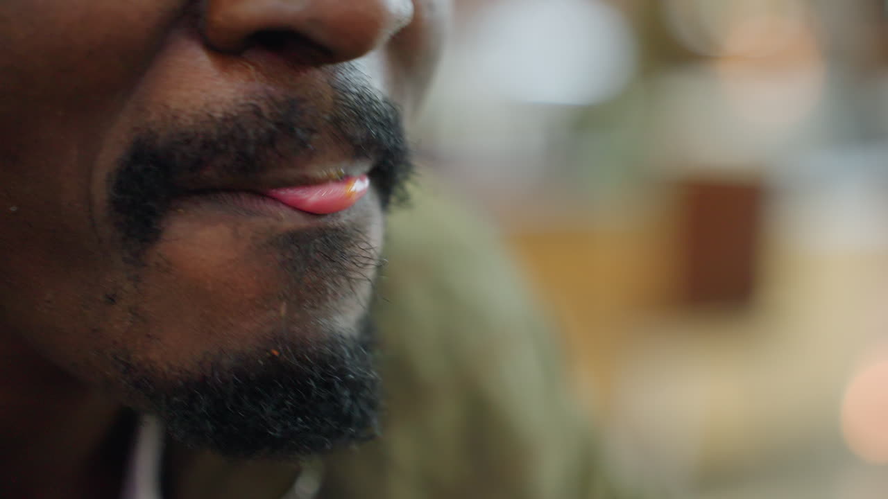 Extreme close up of man eating snack with focused expression, highlighting texture of skin and facial detail, blurred background creating intimate view of lifestyle and food enjoyment