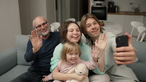 abuelo y nietos se están divirtiendo haciendo selfies o videollamadas a la familia con el teléfono inteligente