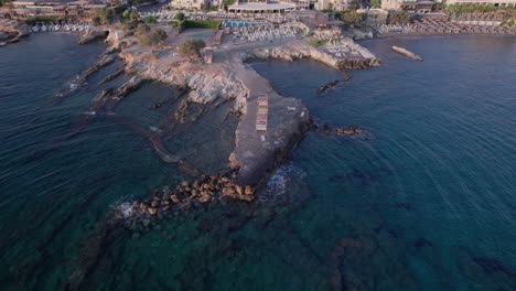 imágenes aéreas de drones después de la puesta del sol sobre una ciudad de creta, mostrando su costa rocosa