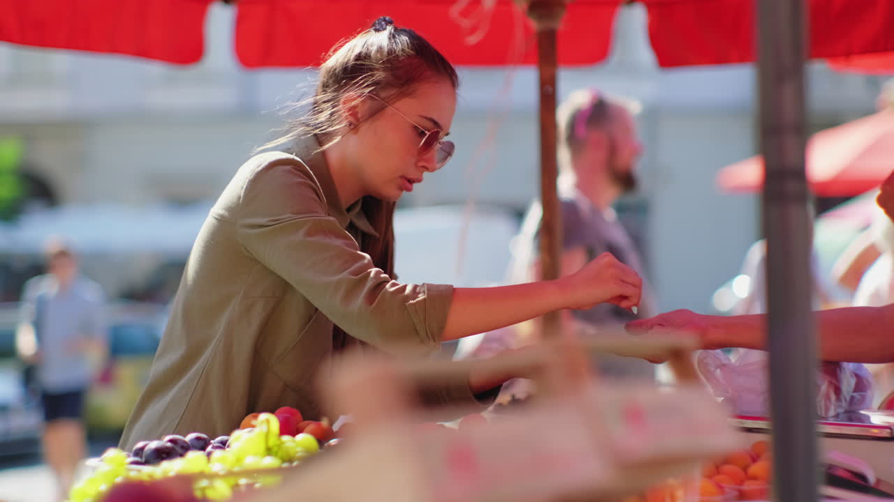 mujer comprando fruta en un mercado callejero