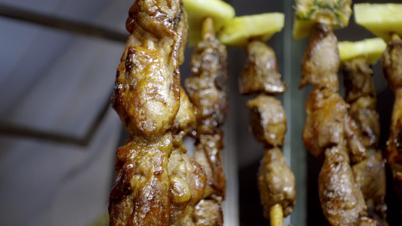 Close-up of grilled skewers at a vibrant festival in Cholula, Puebla