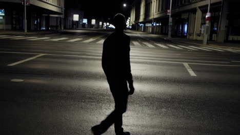 silhouette of a person walking at night