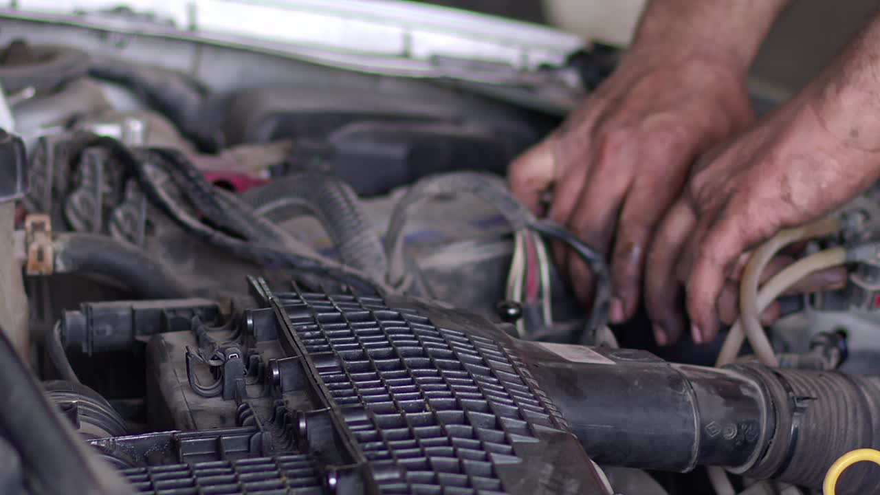 mecánico de automóviles cambiando el filtro de combustible del automóvil en el taller de reparación
