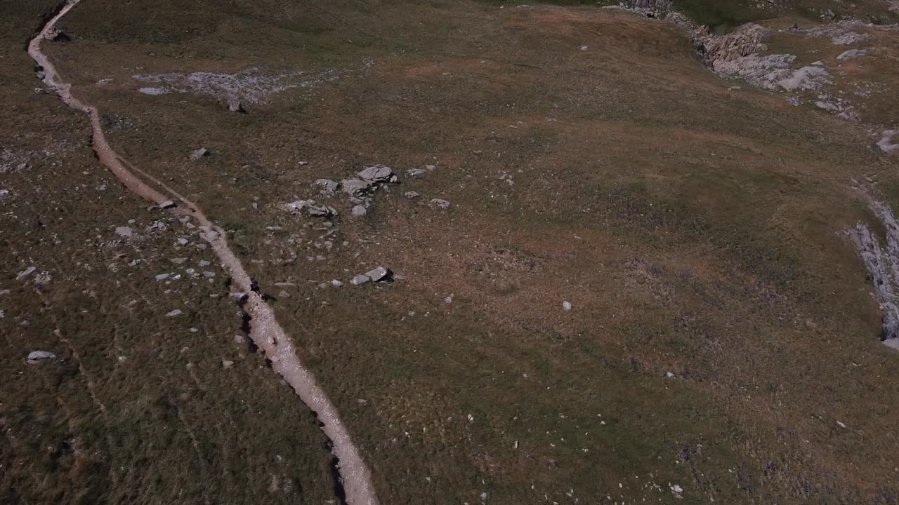 Drone following a woman who practices trail running in the Pyrenees. Running on trails. Running in the mountains. Woman running