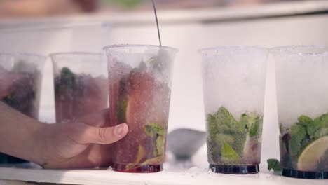 barman on beach prepares refreshing cocktails