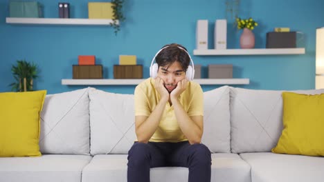 man listening to music with headphones is unhappy and sad.