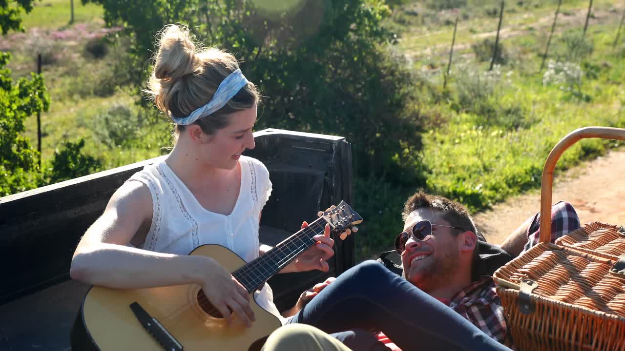mujer tocando la guitarra para el hombre 4k