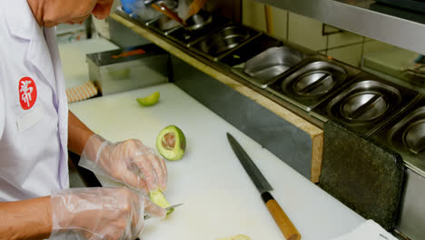 chef masculino cortando frutas de aguacate en la cocina 4k