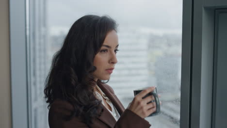 businesswoman enjoy coffee break looking on office window closeup. portrait lady