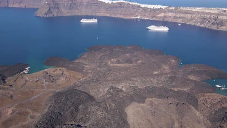 visión general aérea de gran altitud, inclinándose hacia abajo sobre el cráter del volcán en la isla de santorini, grecia en cámara lenta