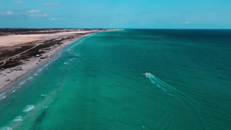 aerial view of a beautiful beach and ocean with a boat