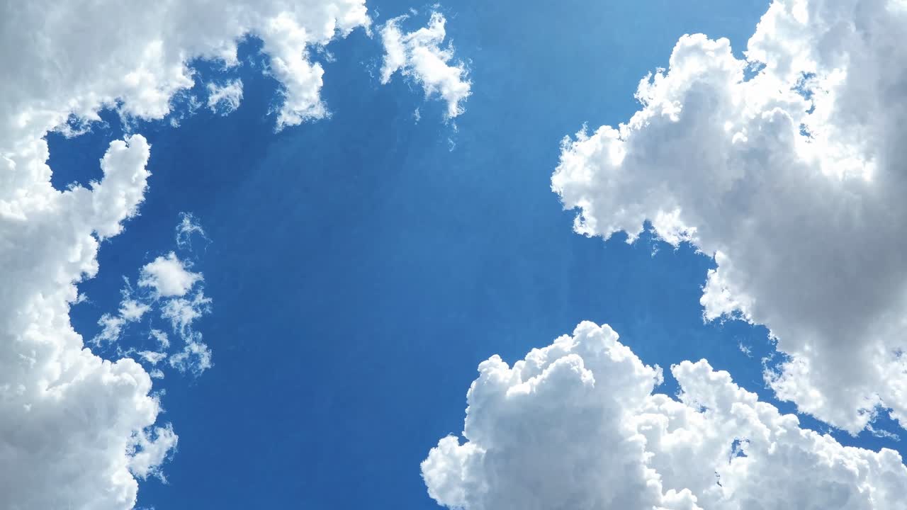Video concept of a bright blue sky with fluffy clouds. Captured from a low angle