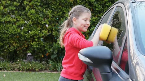 Little-girl-washing-car-with-a-sponge-4K-4k