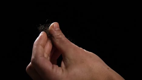 Detalle-De-La-Mano-De-La-Mujer-Con-Pérdida-De-Cabello-Sobre-Fondo-Negro