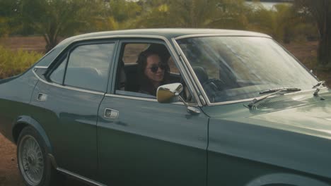 woman driving a vintage green car