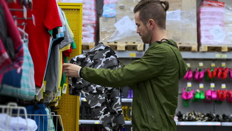 man shopping for kids clothes in a retail store