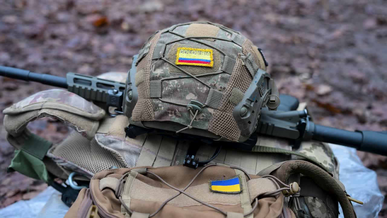 A Colombian flag on a helmet and a Ukrainian flag on gear symbolize international support in Ukraine. The equipment belongs to a volunteer training for the war with Russia