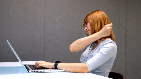 una mujer de negocios asiática tiene dolor en el hombro en el lugar de trabajo. síndrome de oficina.