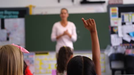 rear view of schoolgirl raising hand in the classroom 4k